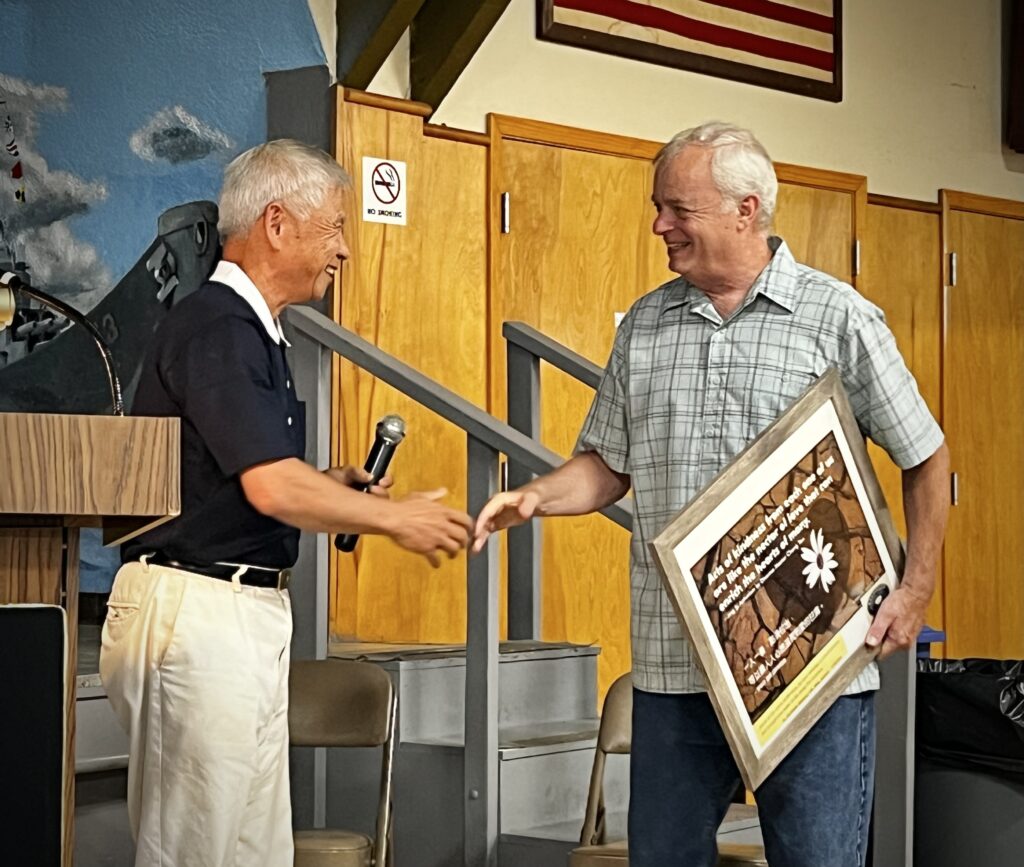 Kevin Cox receiving a gift from the Tzu Chi representative