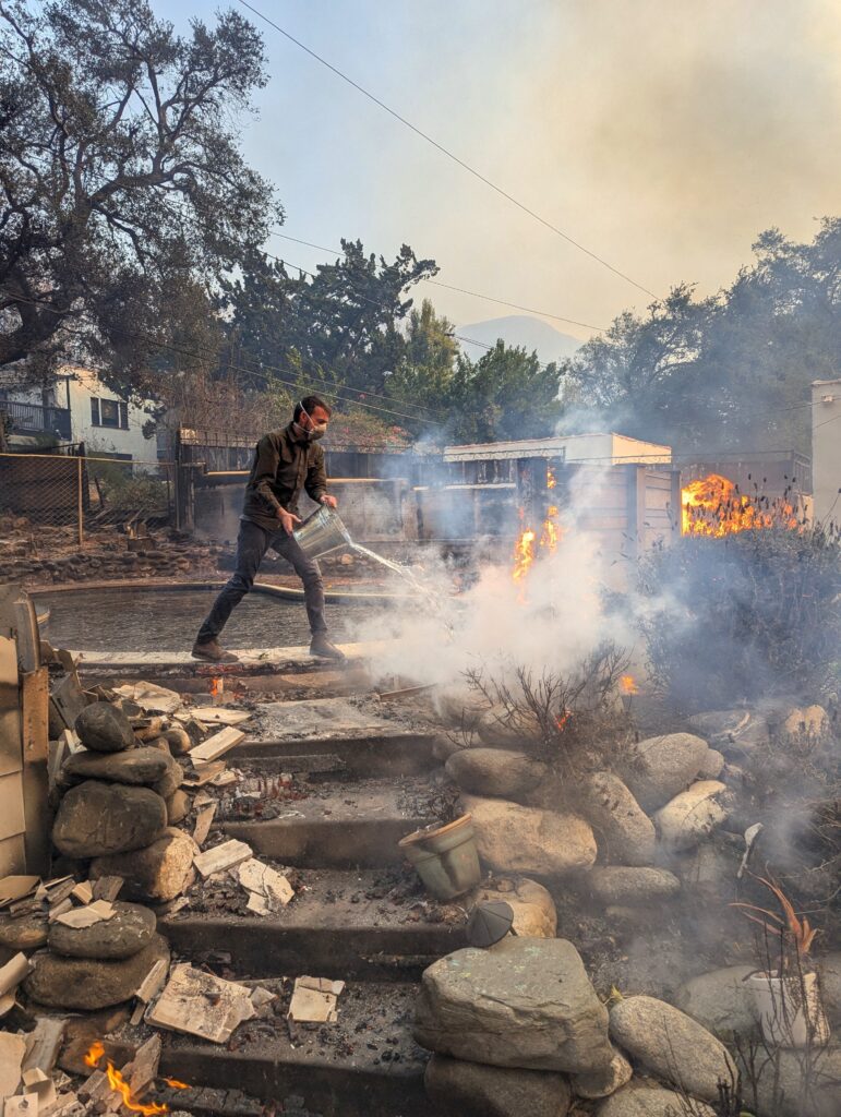 Photo of a homeowner using a pool to fight a fire in their backyard. Photo courtesy of Timithie Norman